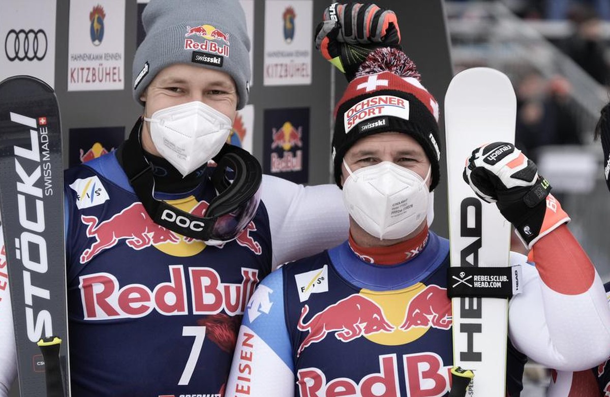 Switzerland's Beat Feuz, center, winner of an alpine ski, men's World Cup downhill, stands with second-placed Switzerland's Marco Odermatt, left, and third-placed Austria's Daniel  ...