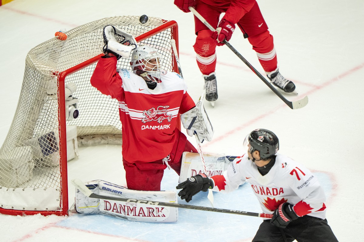 epa12126794 Tyson Foerster, Canada, right, challenges goalkeeper Frederik Dichow, Denmark during the quarter-final match between Canada and Denmark at the IIHF Ice Hockey World Championships in Hernin ...