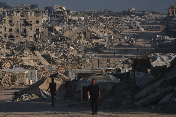 Palestinians walk along a road surrounded by buildings destroyed in Israeli military strikes during the Israel-Hamas war, in Jabalia, Gaza Strip, Thursday, July 2, 2026. (AP Photo/Jehad Alshrafi)
Mide ...