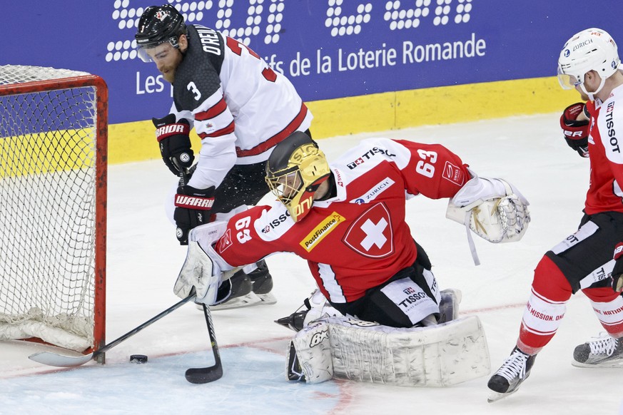 Canada&#039;s forward Ryan O&#039;Reilly, left, vies for the puck with Switzerland&#039;s goaltender Leonardo Genoni, center, past Switzerland&#039;s forward Richard Tanner, right, during a friendly i ...