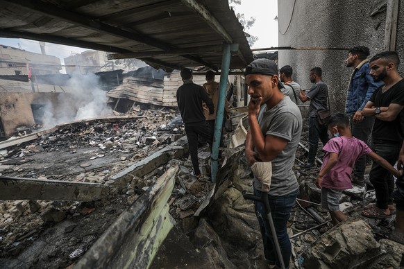 epa11339667 Palestinians inspect a destroyed United Nations school following an air strike in Al Nuseirat refugee camp, central Gaza Strip, 14 May 2024. At least six people were killed in the strike w ...