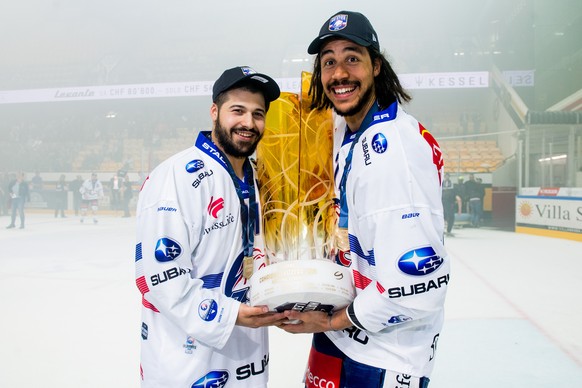 Zurich&#039;s player Inti Pestoni, left and Zurich&#039;s player Samuel Guerra, right, hold up the trophy after winning the Swiss championship title, during the seventh match of the playoff final of t ...