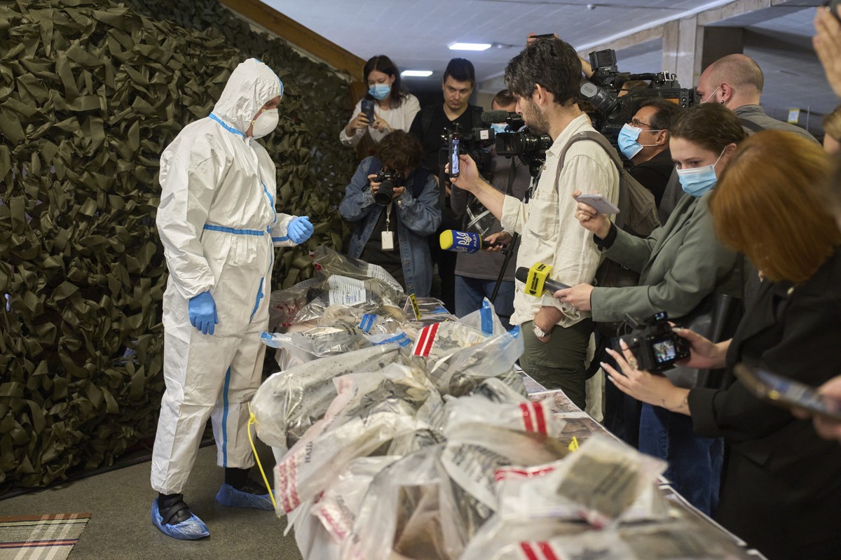 A police expert shows parts of uniform and ammunition of Russian soldiers killed in Russia-Ukraine war during Interior Minister Ihor Klymenko's briefing on repatriation of fallen solders in Kyiv, ...