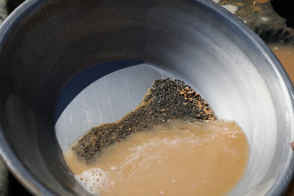 FILE - A pan containing gold-bearing sediment and heavy mineral concentrate sits at an artisanal mining site in Dalago Mahas, Sudan's Northern State,Friday, May 8, 2026. (AP Photo/Mohnd Blal, Fil ...