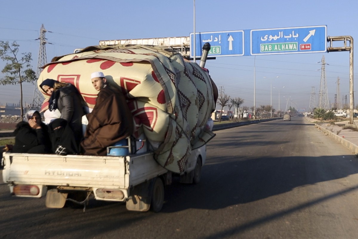 In this frame grab from video taken on Thursday, Dec. 19, 2019, a family with their goods loaded on a lorry drives towards the Turkish border in Syria's rebel-controlled Idlib province. The UN sa ...