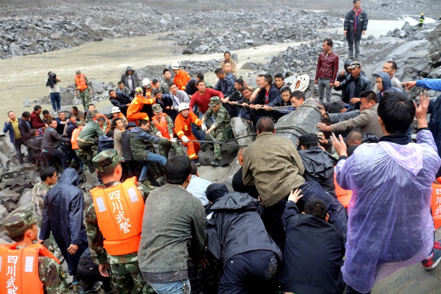 epa06048770 Rescuers work at the site of a massive landslide where over 120 villagers are estimated to be buried, in Maoxian county, southwest China&#039;s Sichuan province, 24 June 2017. Six bodies h ...