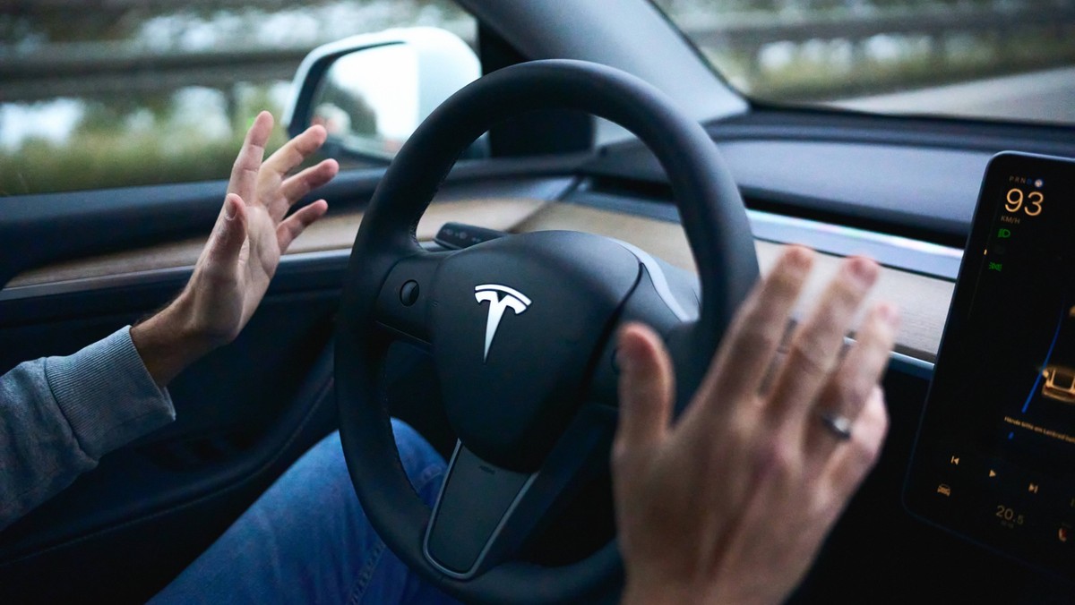 Bavaria, Germany - November 22, 2024: Symbolic image for autonomous driving with a Tesla. The driver of a Tesla electric car keeps his hands away from the steering wheel while the vehicle is driving a ...