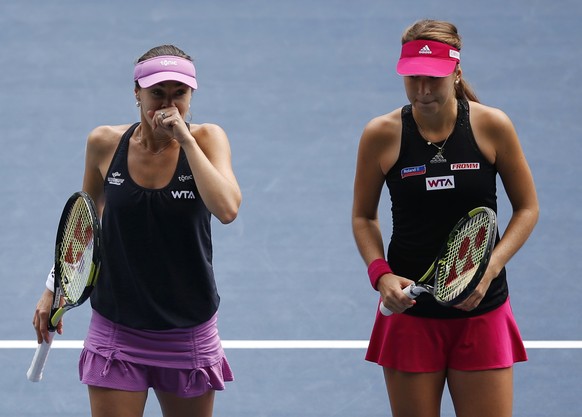 Martina Hingis (L) of Switzerland and her partner and compatriot Belinda Bencic react after losing a point during their Pan Pacific Open women&#039;s doubles tennis match against Cara Black of Zimbabw ...