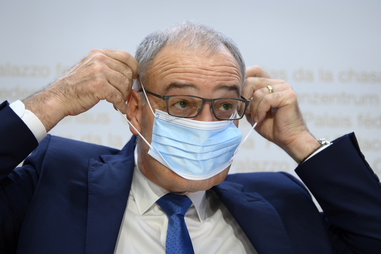 Bundesratspraesident Guy Parmelin zieht seine Maske an am Ende einer Medienkonferenz ueber das weitere Vorgehen gegen die Ausbreitung des Coronavirus (COVID-19): Recovery Programm und die Aussichten f ...