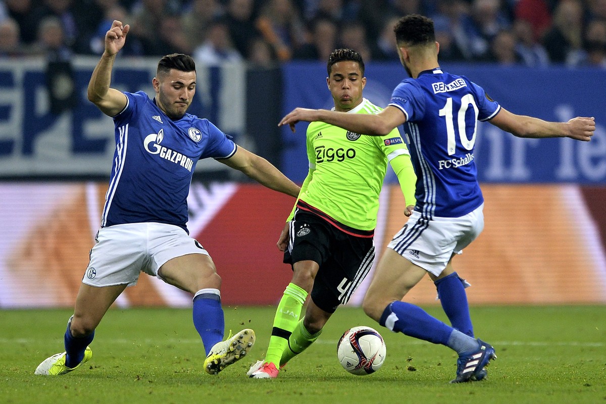 epa05917936 Amsterdam's Justin Kluivert (C) is challenged by Schalke's Sead Kolasinac (L) and Nabil Bentaleb (R) during the UEFA Europa League quarter final, second leg soccer match between  ...