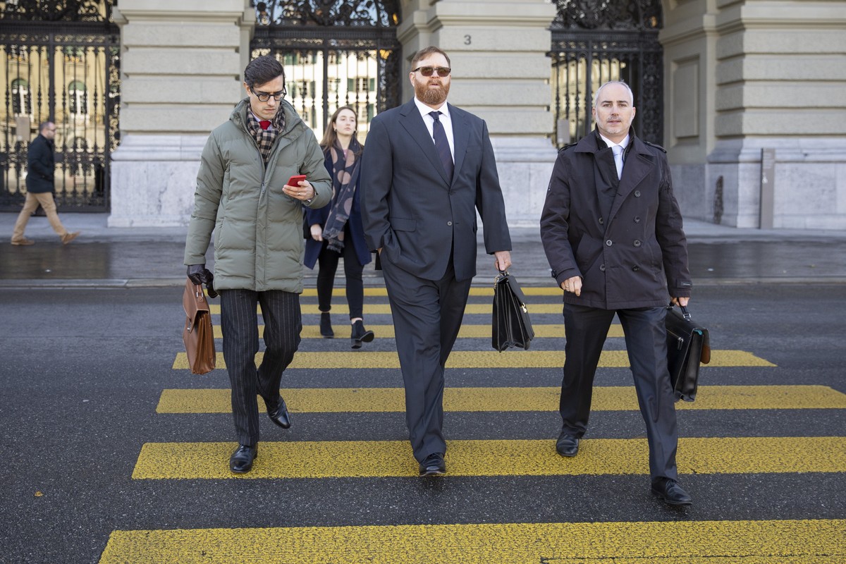 epa07992689 Former head of Guatemala's national police Erwin Sperisen (C) with his lawyers Florian Baier (R) and Giorgio Campa (L) arrive at the Parliament Buildung 'Bundeshaus', before ...