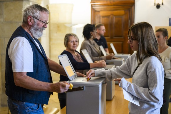 epa10932364 A woman casts her ballot during the Swiss Federal Elections in Delemont, Switzerland, 22 October 2023. On 22 October Swiss citizens will elect a new parliament. The Swiss voters elect thei ...