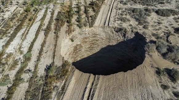 Aerial view taken on August 1, 2022, showing a large sinkhole that appeared over the weekend near the mining town of Tierra Amarilla, Copiapo Province, in the Atacama Desert in Chile. A 100-metre secu ...