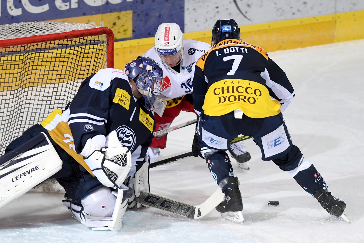 Ambri's goalkeeper Benjamin Conz, Laker's player Kevin Clark and Ambri's player Isacco Dotti, from left, fight for the puck, during the preliminary round game of National League Swiss C ...