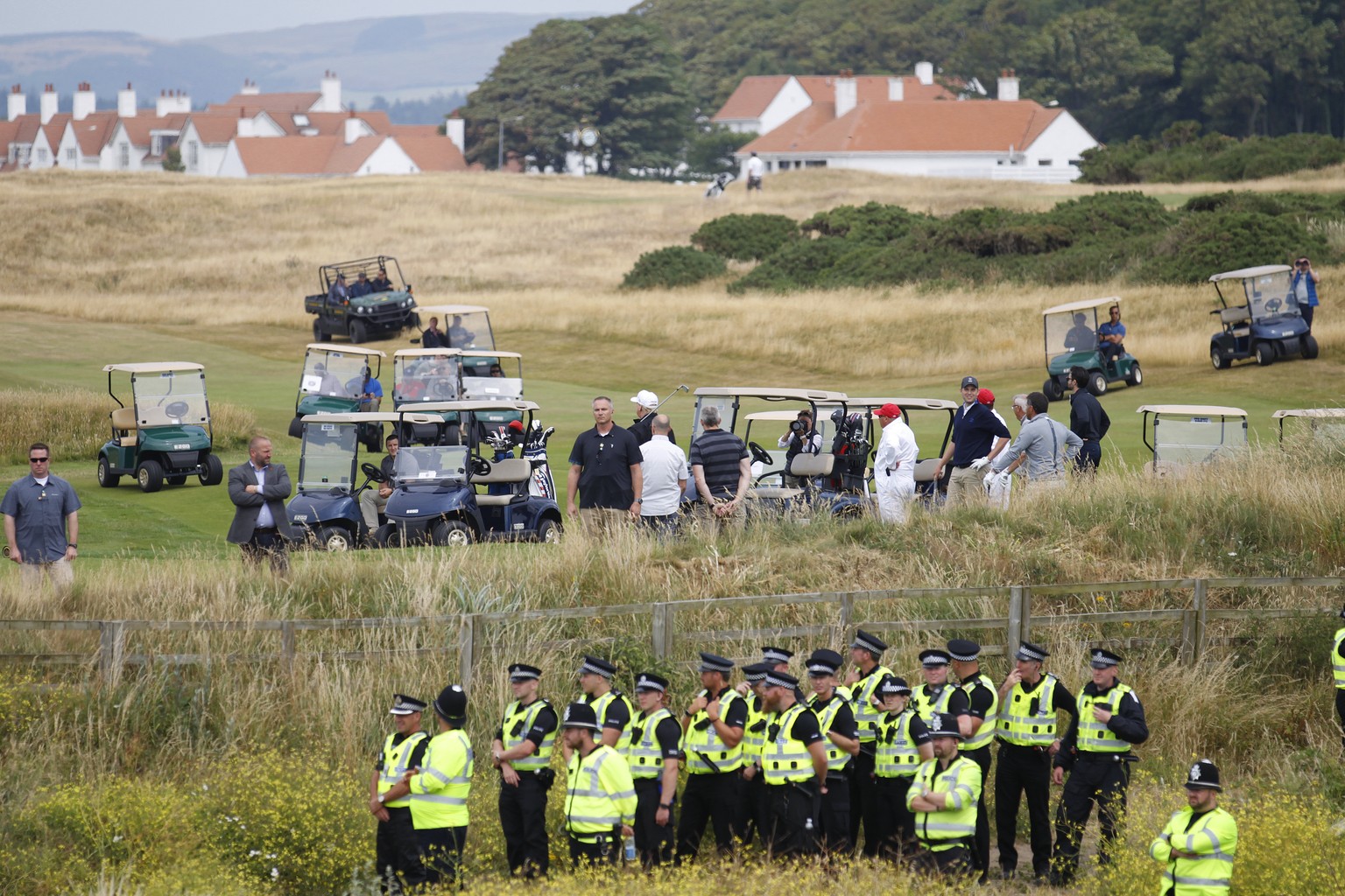 U.S. President Donald Trump plays golf under tight security at Turnberry golf club, in Turnberry, Scotland, Saturday, July 14, 2018. A dozen demonstrators have staged a protest picnic on the beach in  ...