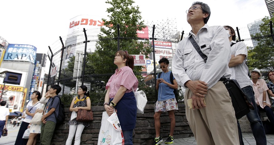epa05464074 Pedestrians watch a large screen broadcasting Japanese Emperor Akihito's video message (unseen) on his thoughts, in Tokyo, Japan, 08 August 2016. Japanese Emperor Akihito expressed hi ...