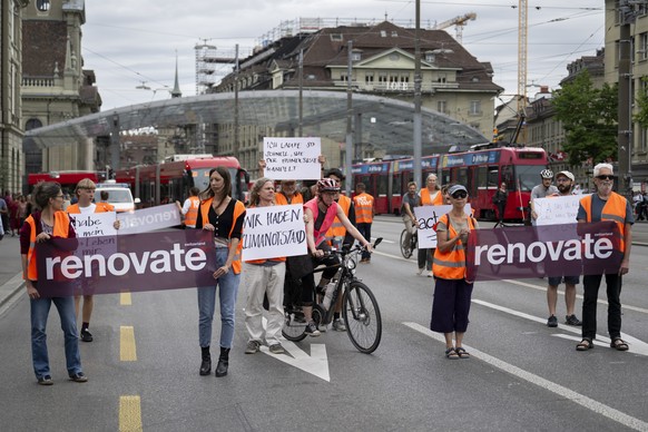 Environmental activists of Renovate Switzerland protest during a slow protest march on a road in Bern, Switzerland, on Saturday, July 1, 2023. (KEYSTONE/Anthony Anex)
