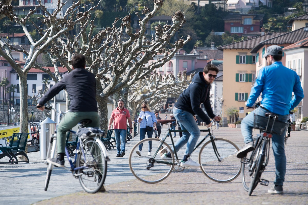 Leute geniessen das schone Wetter an der Uferpromenade von Ascona, am Samstag, 4. April 2020. Bundesrat und Tessiner Regierung hatten schon fuer das vergangene Wochenende explizit dazu aufgerufen, nic ...