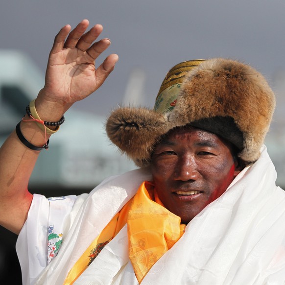 FILE - In this May 20, 2018, file photo, Nepalese veteran Sherpa guide, Kami Rita, 48, waves as he arrives in Kathmandu, Nepal. Rita has scaled Mount Everest for a 23rd time, breaking his own record f ...