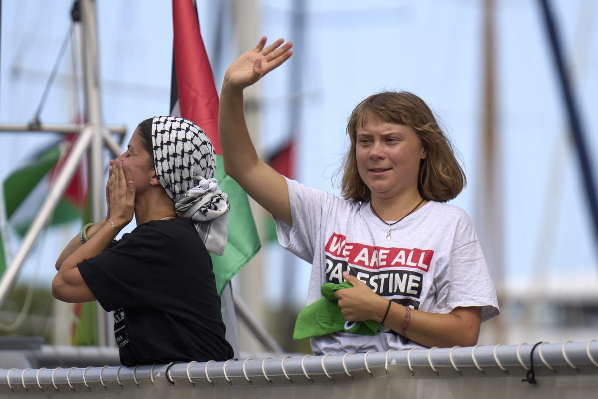 Swedish climate activist Greta Thunberg waves from a boat taking part in a civilian flotilla bound for Gaza, aiming to break the Israeli blockade and deliver humanitarian aid, in Barcelona, Spain, Sun ...