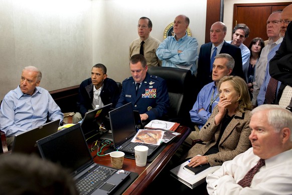 U.S. President Barack Obama (2nd L) and Vice President Joe Biden (L) and Secretary of State Hillary Clinton (seated, 2nd R), along with members of the national security team, receive an update on the  ...