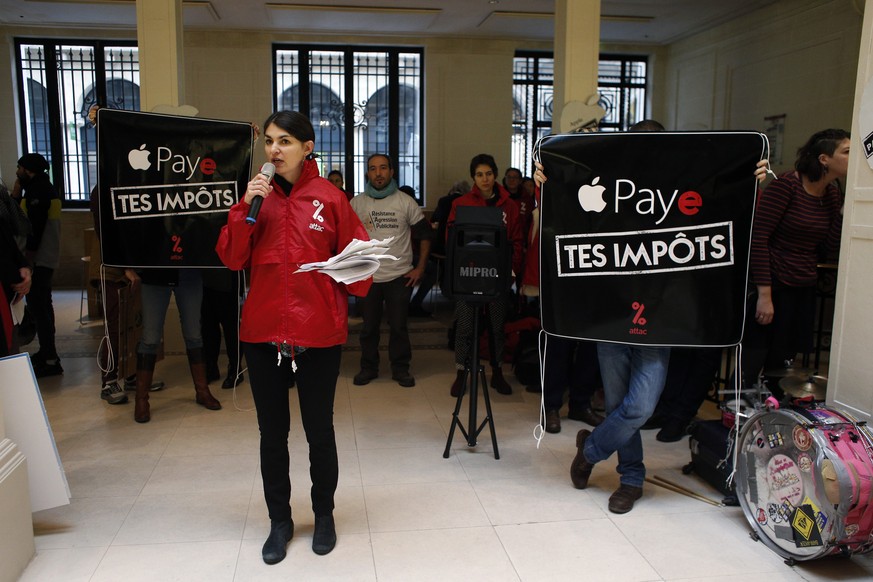 Activists from anti-globalization organisation &#039;Attac&#039; protest about allegations that Apple has avoided tens of billions of dollars in taxes by using overseas havens, in an Apple store, in P ...