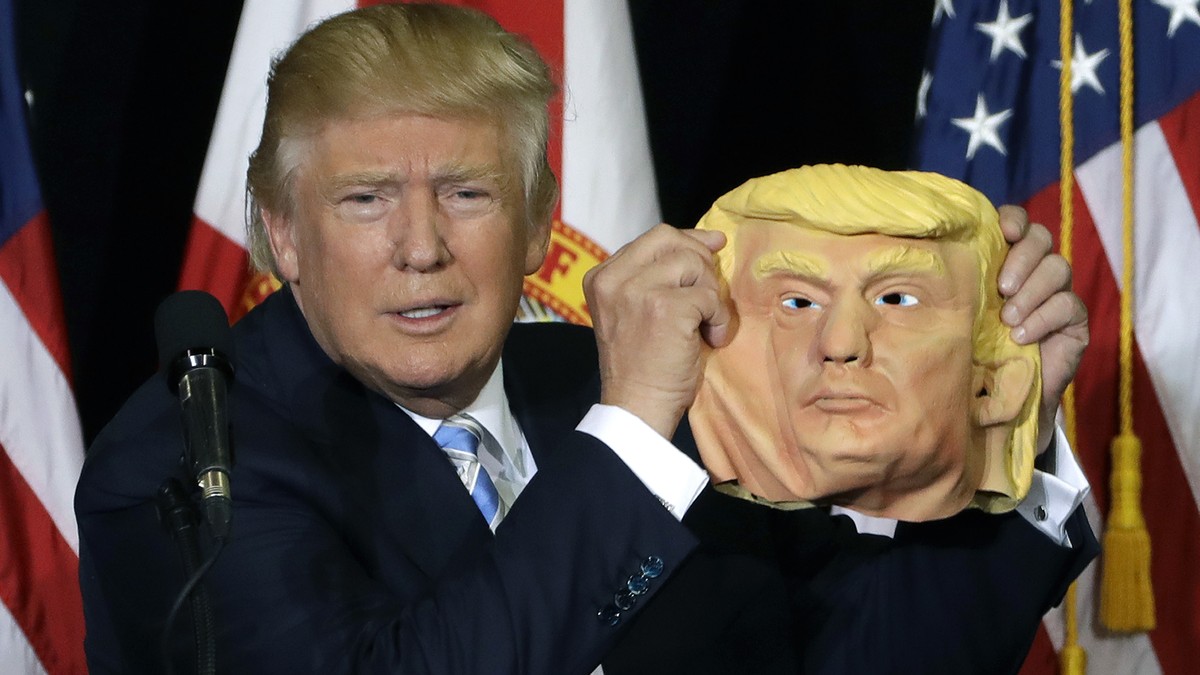 Republican presidential candidate Donald Trump holds up a Donald Trump mask during a campaign speech, Monday, Nov. 7, 2016, in Sarasota, Fla. (AP Photo/Chris O'Meara)