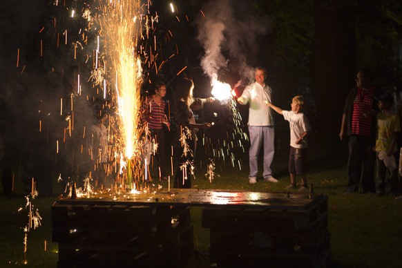 ZUM FEUERWERKSVERBOT FUER DEN ERSTEN AUGUST IM KANTON BERN STELLEN WIR IHNEN AM DONNERSTAG, 23. JULI 2015, FOLGENDES ARCHIVBILD ZUR VERFUEGUNG - Children and their parents burn fireworks, during the S ...