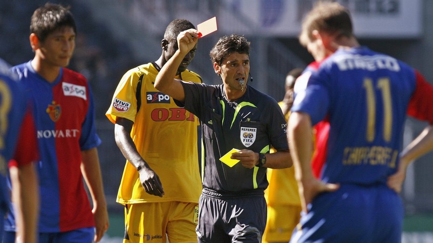 Der Schiedsrichter Massimo Busacca, Mitte, zeigt dem Basler Koji Nakata, links, die rote Karte nach der zweiten Verwarnung, dessen Teamkollege Scott Chipperfield, rechts, laesst den Kopf haengen, waeh ...