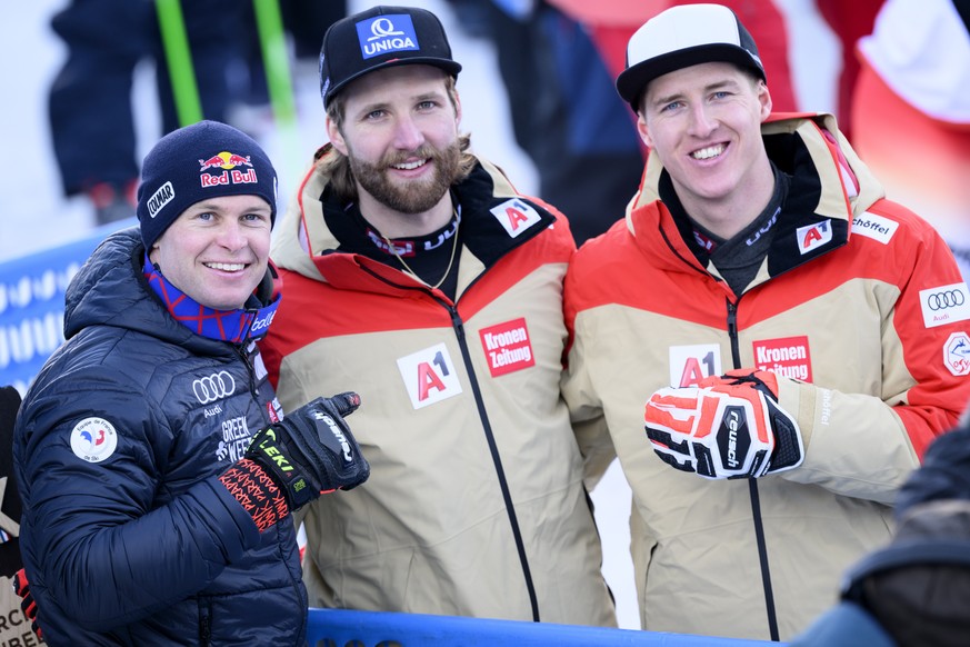 epa10452755 World champion Alexis Pinturault of France, left, Silver medalist Marco Schwarz of Austria, center, and Raphael Haaser of Austria, right, react in the finish area during the slalom run of  ...