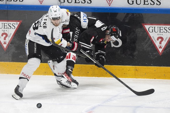 From left Fribourg&#039;s player Christoph Bertschy and Lugano?s player Marco Zanetti, during the preliminary round game of National League 2022/23 between HC Lugano and HC Fribourg-Gotteron at the Co ...