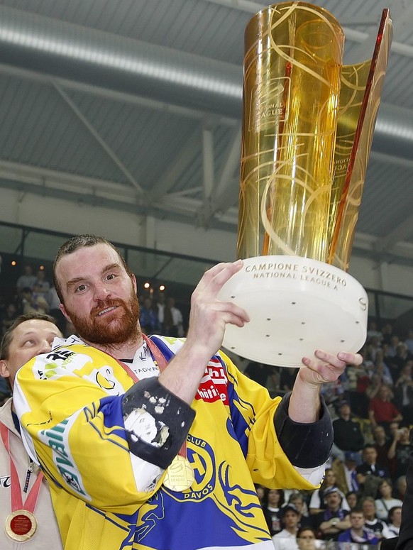 HC Davos Verteidiger Marc Gianola stemmt den Pokal in die Hoehe bei der Siegerehrung nach dem Gewinn des Meistertitels im siebten der Best of Seven Serie Eishockey Playoff-Final-Spiel der National Lea ...