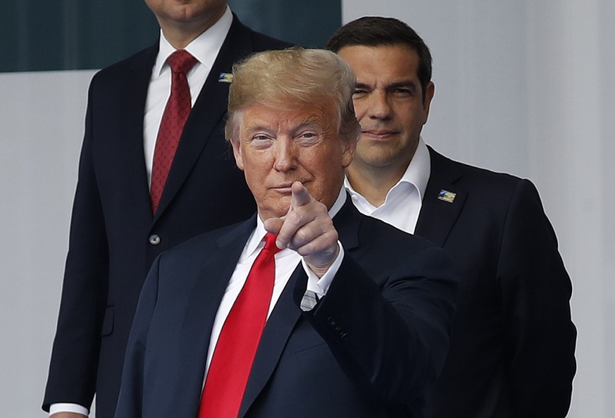 President Donald Trump points with his fingers towards members of the media during a family photo at a summit of heads of state and government at NATO headquarters in Brussels on Wednesday, July 11, 2 ...