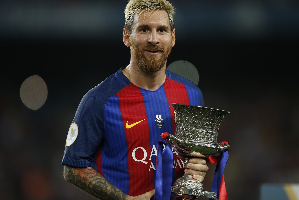 FC Barcelona's Lionel Messi celebrates with the trophy after winning the Spanish Super Cup between FC Barcelona and Sevilla at the Camp Nou in Barcelona, Spain, Thursday, Aug. 18, 2016. (AP Photo ...
