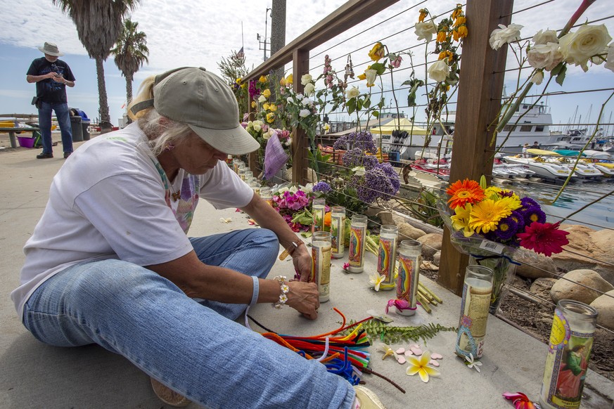 epa07815474 Stephanie Stafford makes arraignments to a makeshift memorial near the docks of Truth Aquatics after its 75-foot Conception commercial diving boat burned and sank near Santa Cruz Island, o ...