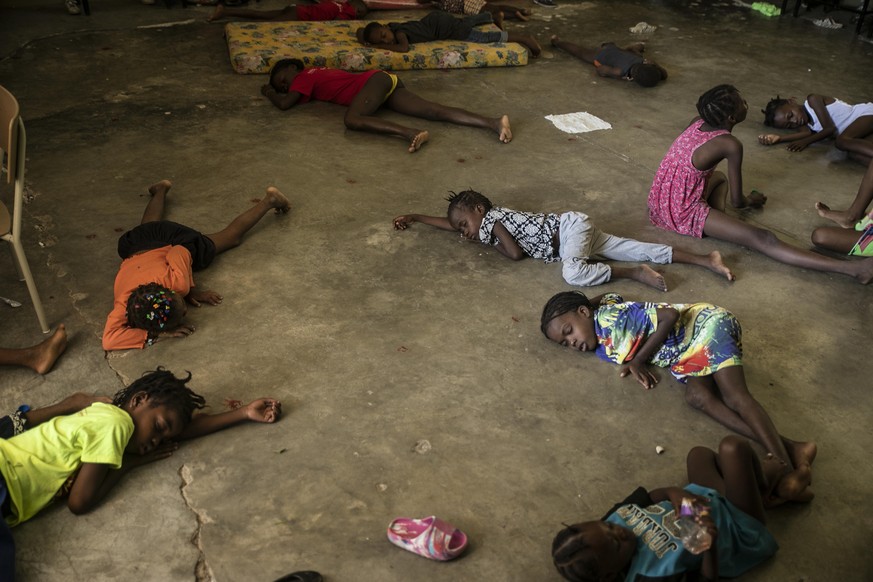 FILE - Children sleep on the floor of a school turned into a shelter after they were forced to leave their homes in Cite Soleil due to clashes between armed gangs, in Port-au-Prince, Haiti, July 23, 2 ...