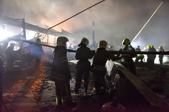 epa10037547 Firefighters and rescue workers clean the rubble of destroyed Amstor shopping mall in Kremenchuk, Poltava Oblast, Ukraine, 27 June 2022. At least eleven bodies were found dead at the scene ...