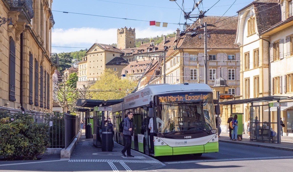Neuchâtel, Suisse - 19 avril 2025 : Un trolleybus électrique pour les transports en commun s'arrête devant les bâtiments historiques du centre-ville.