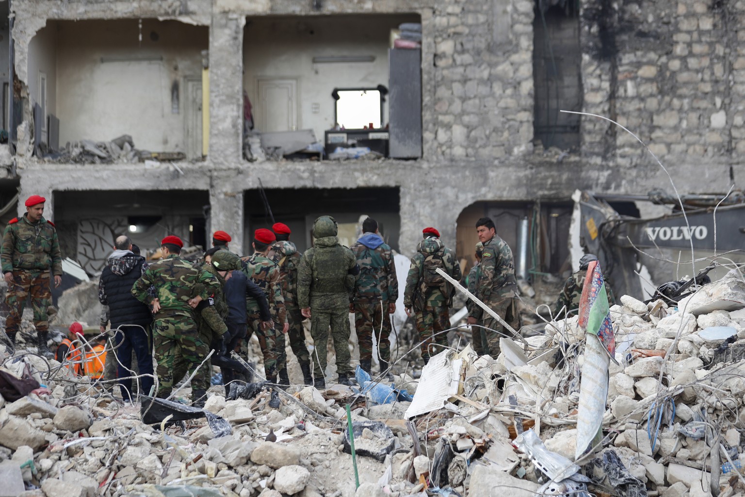 Russian soldiers and Syrian security forces inspect the wreckage of collapsed buildings, in Aleppo, Syria, Tuesday, Feb. 7, 2023. Rescuers raced Tuesday to find survivors in the rubble of thousands of ...
