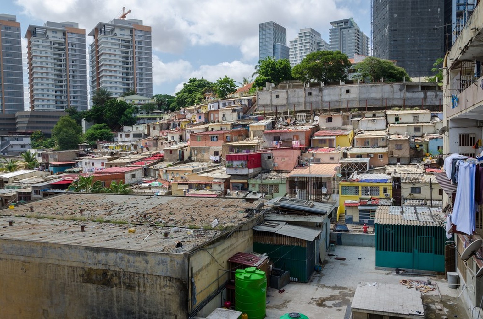Farbige Häuser der armen Einwohner von Luanda, Angola. Diese Gettos ähneln brasilianischen Favelas. Im Hintergrund bilden die Hochhäuser der Reichen einen krassen Kontrast.