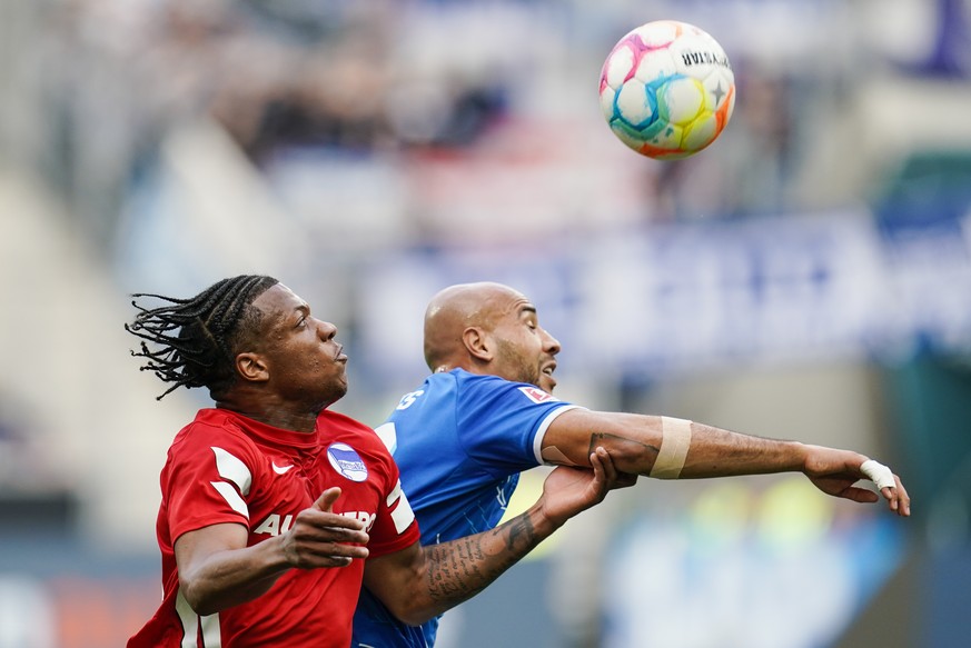 18.03.2023, Baden-W�rttemberg, Sinsheim: Fu�ball: Bundesliga, TSG 1899 Hoffenheim - Hertha BSC, 25. Spieltag, PreZero Arena. Berlins Jessic Ngankam (l) und Hoffenheims John Anthony Brooks k�mpfen um d ...