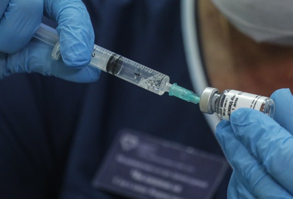 epa08675837 A Russian medical worker prepares a trial vaccine against COVID-19 for a volunteer in a post-registration phase of the test at outpatient hospital number 68 in Moscow, Russia, 17 September 2020. Russia registered the new vaccine called 'Sputnik V' against Coronavirus Sars-Cov-2 and opens the stage of its massive testing. EPA/SERGEI ILNITSKY