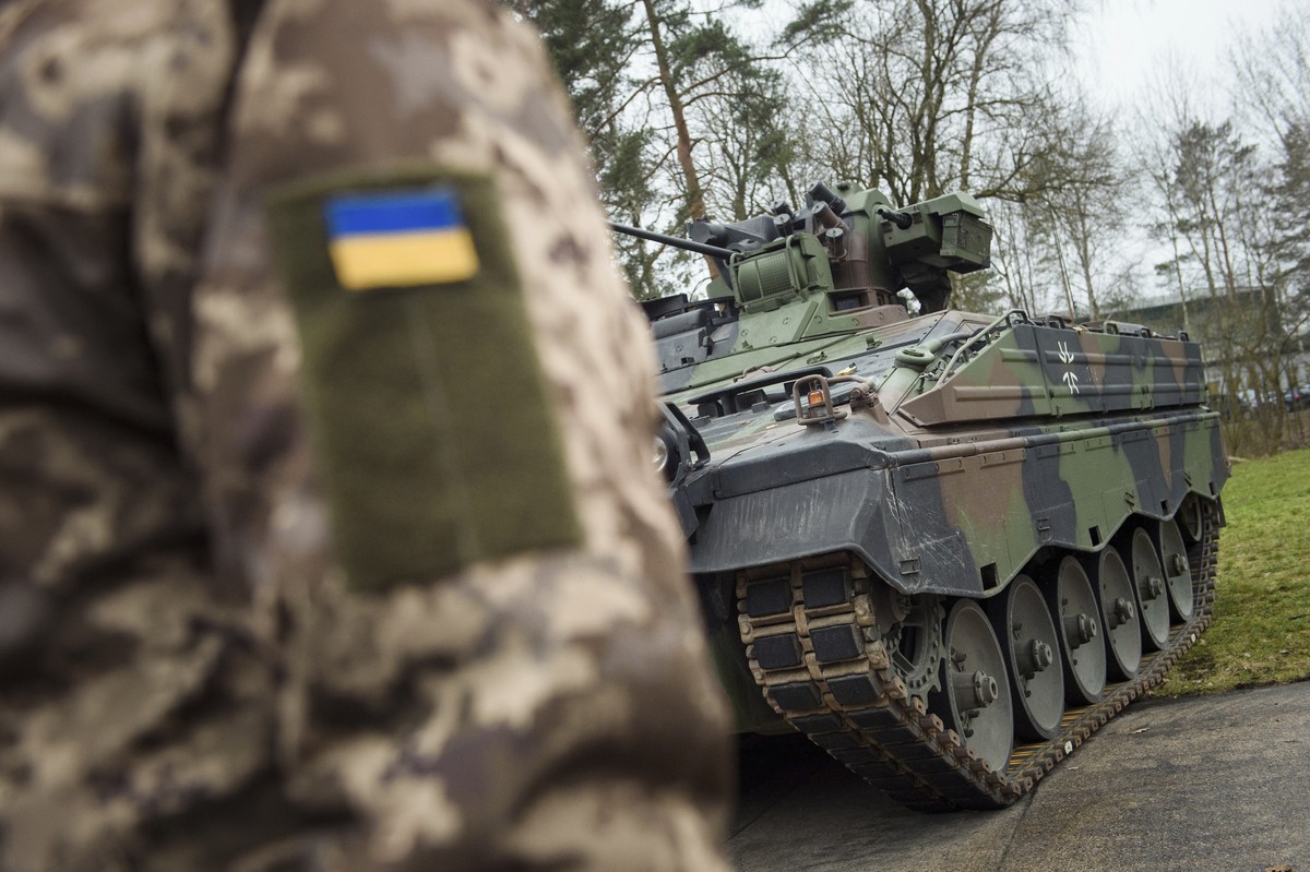 FILE - A Ukrainian soldier is standing in front of a Marder infantry fighting vehicle at the German forces Bundeswehr training area in Munster, Germany, on Feb. 20, 2023. Germany's aid for Ukrain ...
