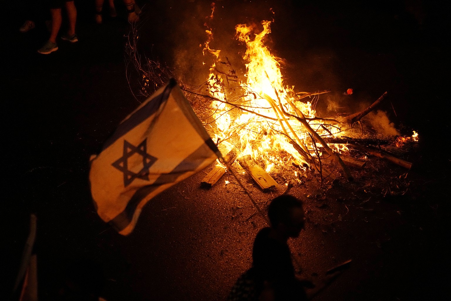 A bonfire burns as Israelis protest against plans by Prime Minister Benjamin Netanyahu&#039;s government to overhaul the judicial system, in Tel Aviv, Israel, Tuesday, July 18, 2023. (AP Photo/Ariel S ...