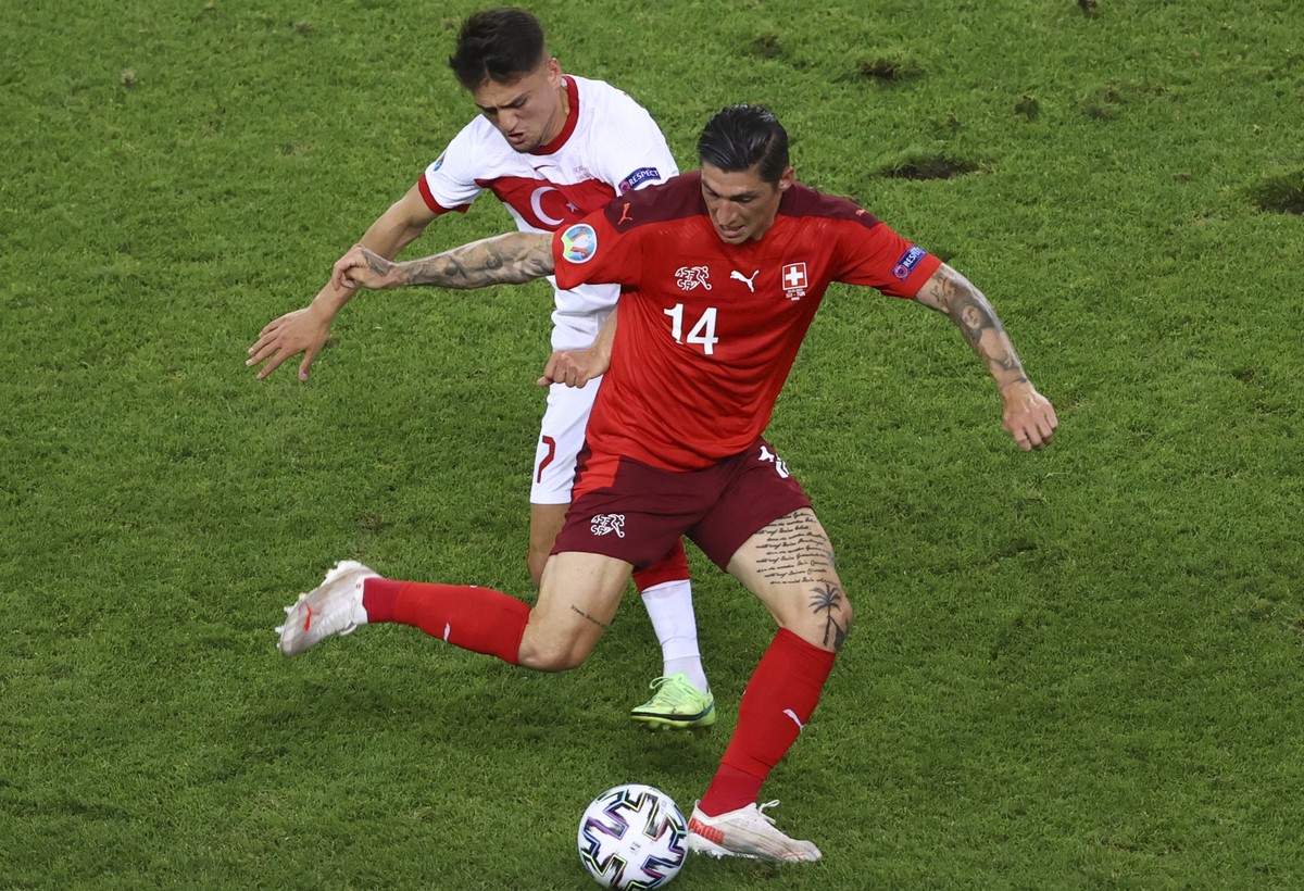 Turkey's Cengiz Under, background, tries to stop Switzerland's Steven Zuber during the Euro 2020 soccer championship group A match between Switzerland and Turkey at the Baku Olympic Stadium  ...