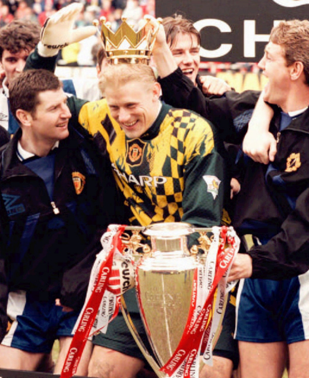 Manchester United's Danish goalkeeper Peter Schmeichel is flanked by celebrating teammates Dennis Irwin, left and Steve Bruce, right, after United clinched the English Premier League title by bea ...