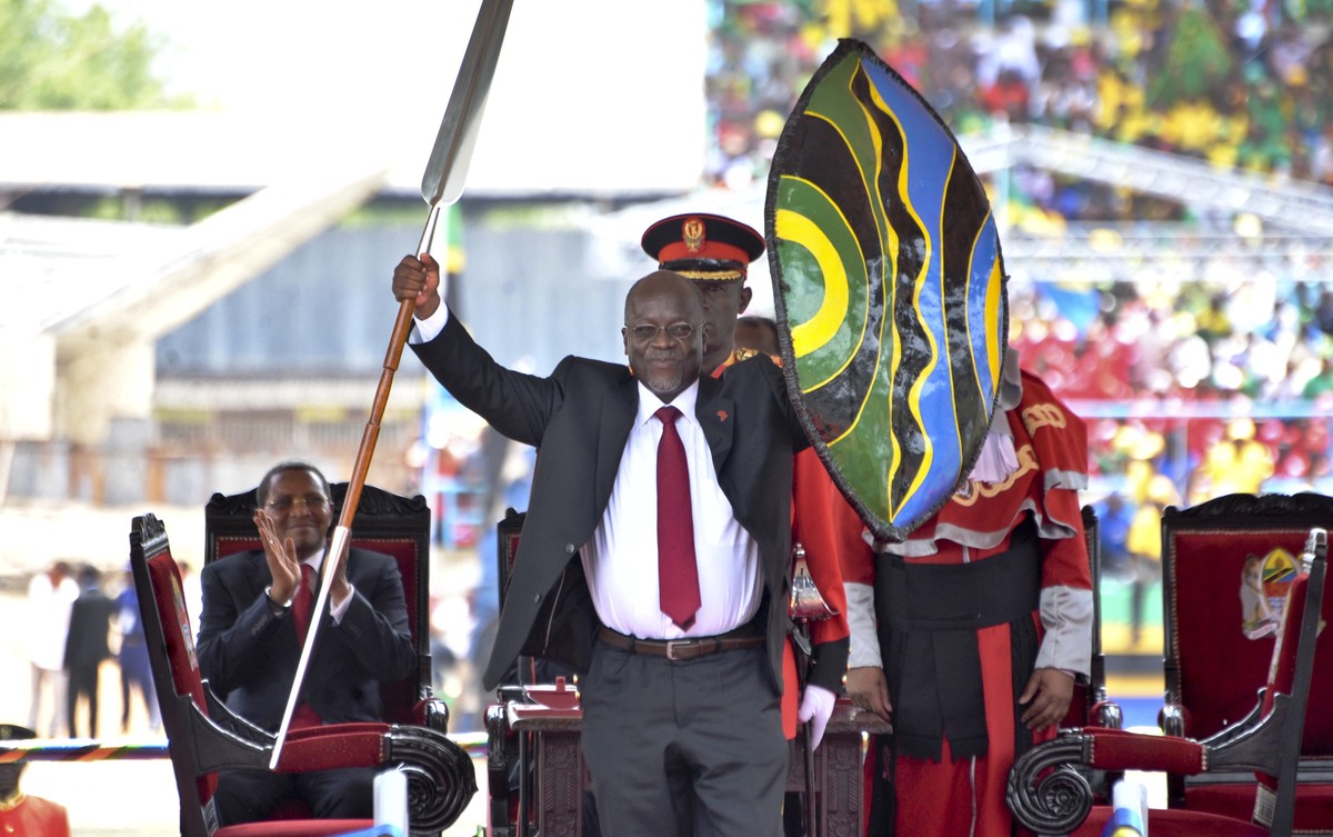 FILE - In this Thursday, Nov. 5, 2015 file photo, Tanzania's President John Magufuli holds up a ceremonial spear and shield to signify the beginning of his presidency, shortly after swearing an o ...