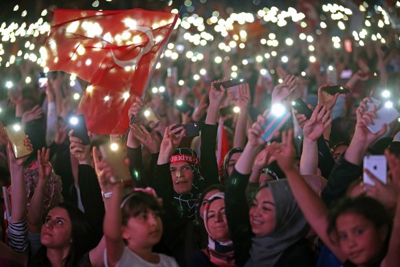 epa06837754 Supporters of Turkish President Recep Tayyip Erdogan hold Turkish and AK Party flags and celebrate after closing voting for the Turkish presidential and parliamentary elections in Ankara,  ...