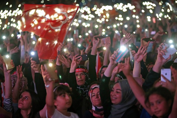 epa06837754 Supporters of Turkish President Recep Tayyip Erdogan hold Turkish and AK Party flags and celebrate after closing voting for the Turkish presidential and parliamentary elections in Ankara, ...