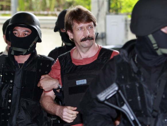 FILE - Suspected Russian arms smuggler Viktor Bout, center, is led by armed Thai police commandos as he arrives at the criminal court in Bangkok, Thailand in Oct. 5, 2010. The Associated Press and oth ...